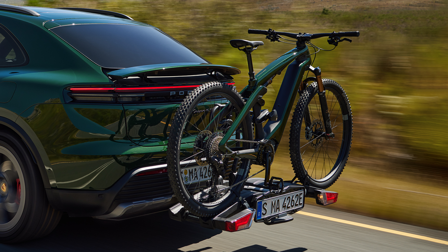 Shows Picture of oakgreen_Porsche_Macan_with_an_oakgreen_Porsche_eBike_on_a_rack.png