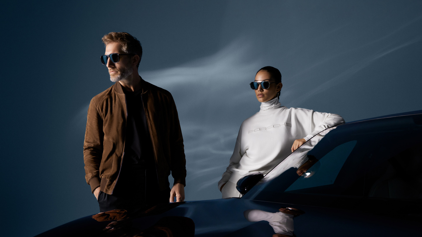 Shows Picture of man-and-woman-standing-next-to-porsche-car-wearing-porsche-design-fashion-v2.jpg