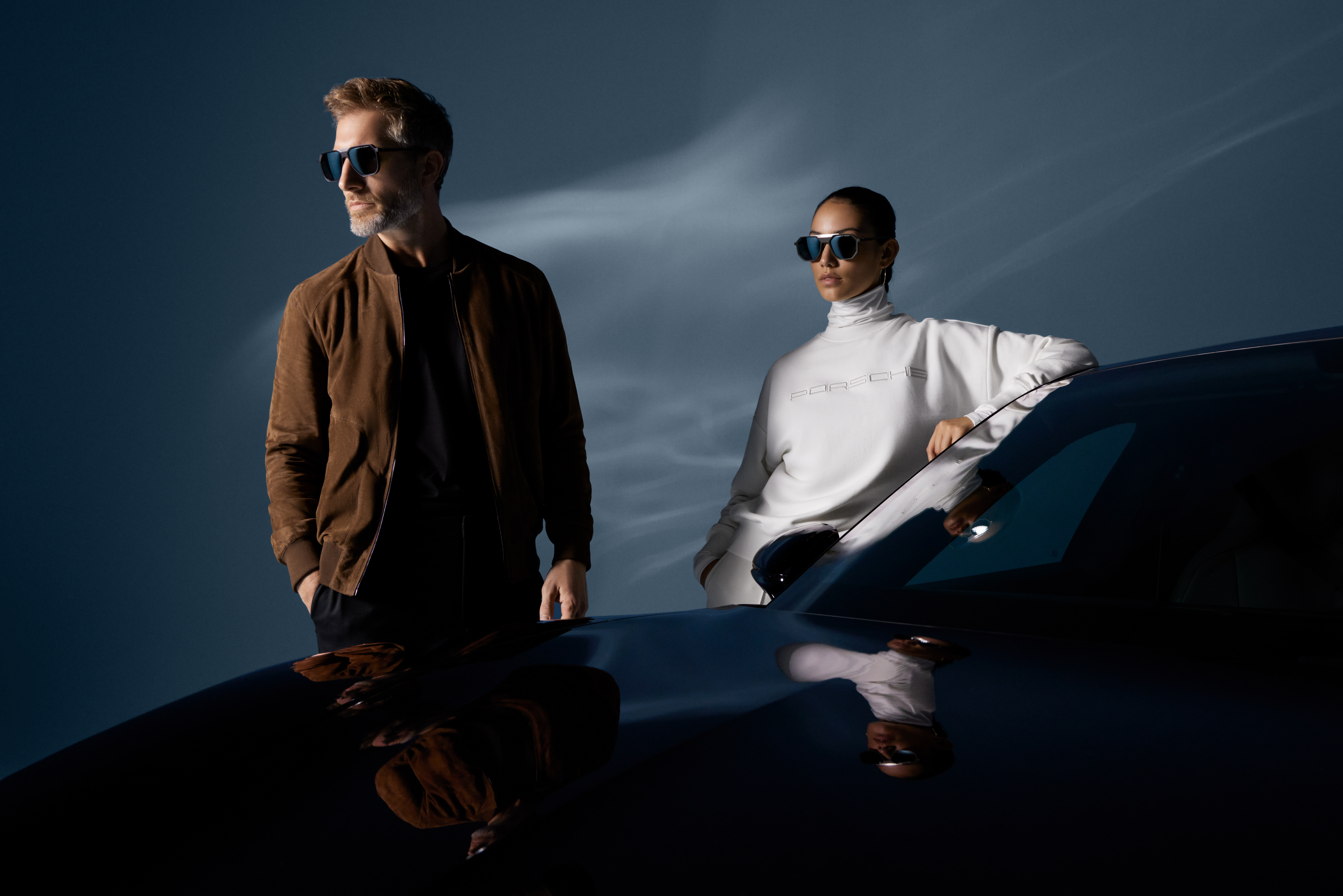 Shows Picture of man-and-woman-standing-neyt-to-porsche-car-wearing-porsche-design-fashion.jpg