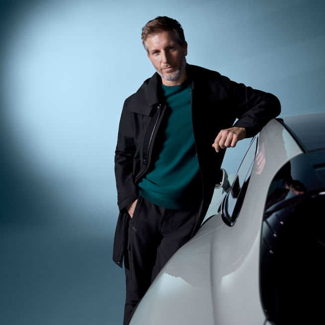 Shows Picture of man-wearing-porsche-design-sportswear-in-leaning-on-white-porsche.jpg.jpg