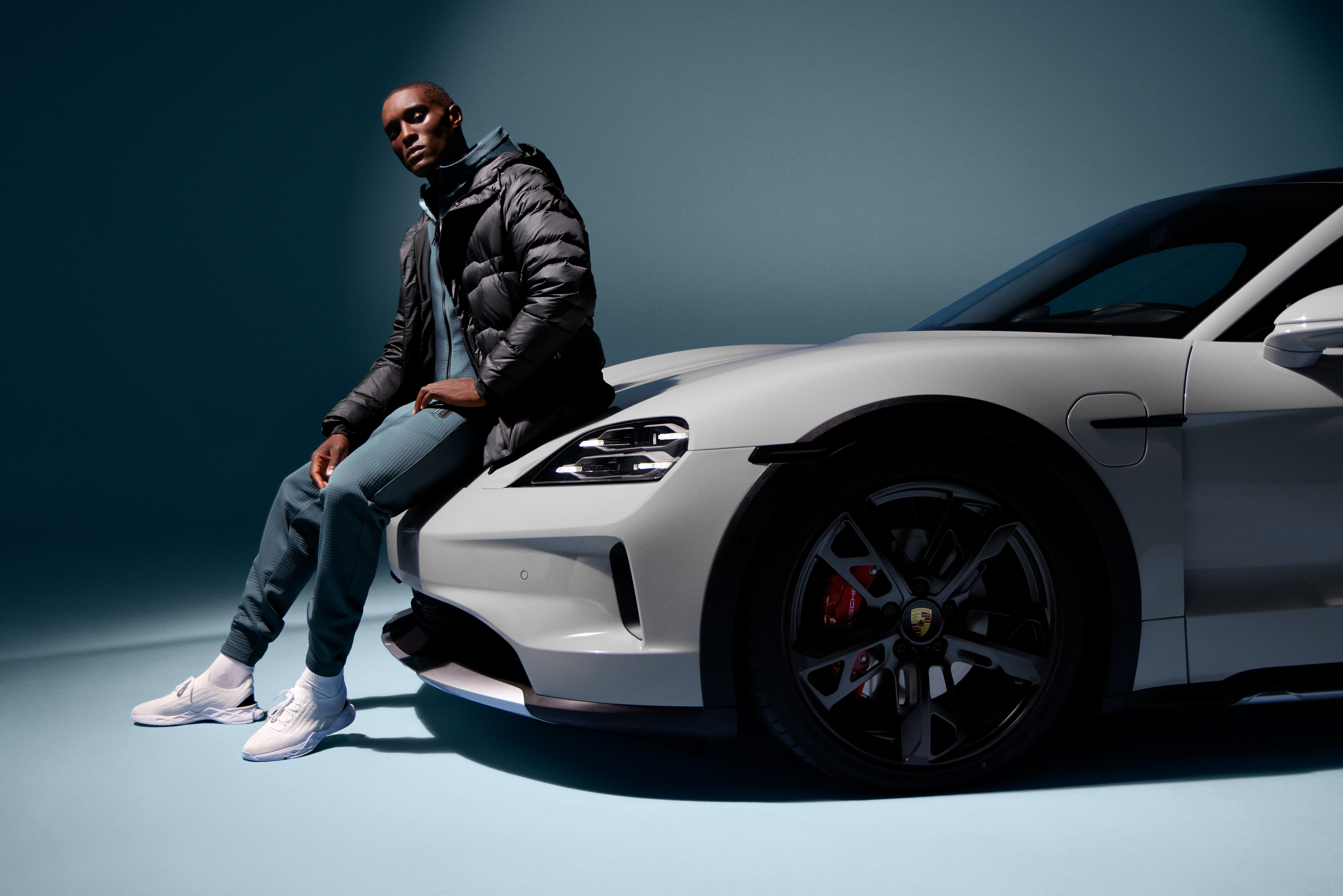 Shows Picture of man-wearing-porsche-design-sportswear-sitting-on-front-of-white-porsche.jpg.jpg