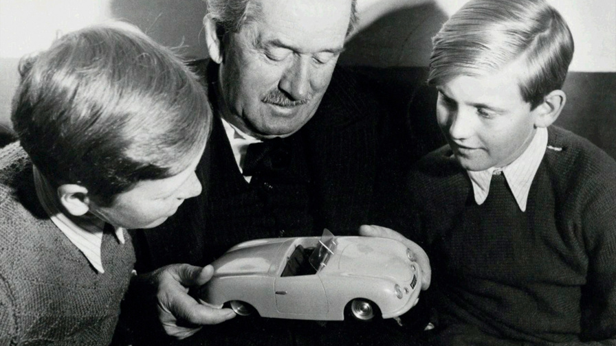 PROFESSOR FERDINAND ALEXANDER PORSCHE looking with his grandfather on an Porsche model.